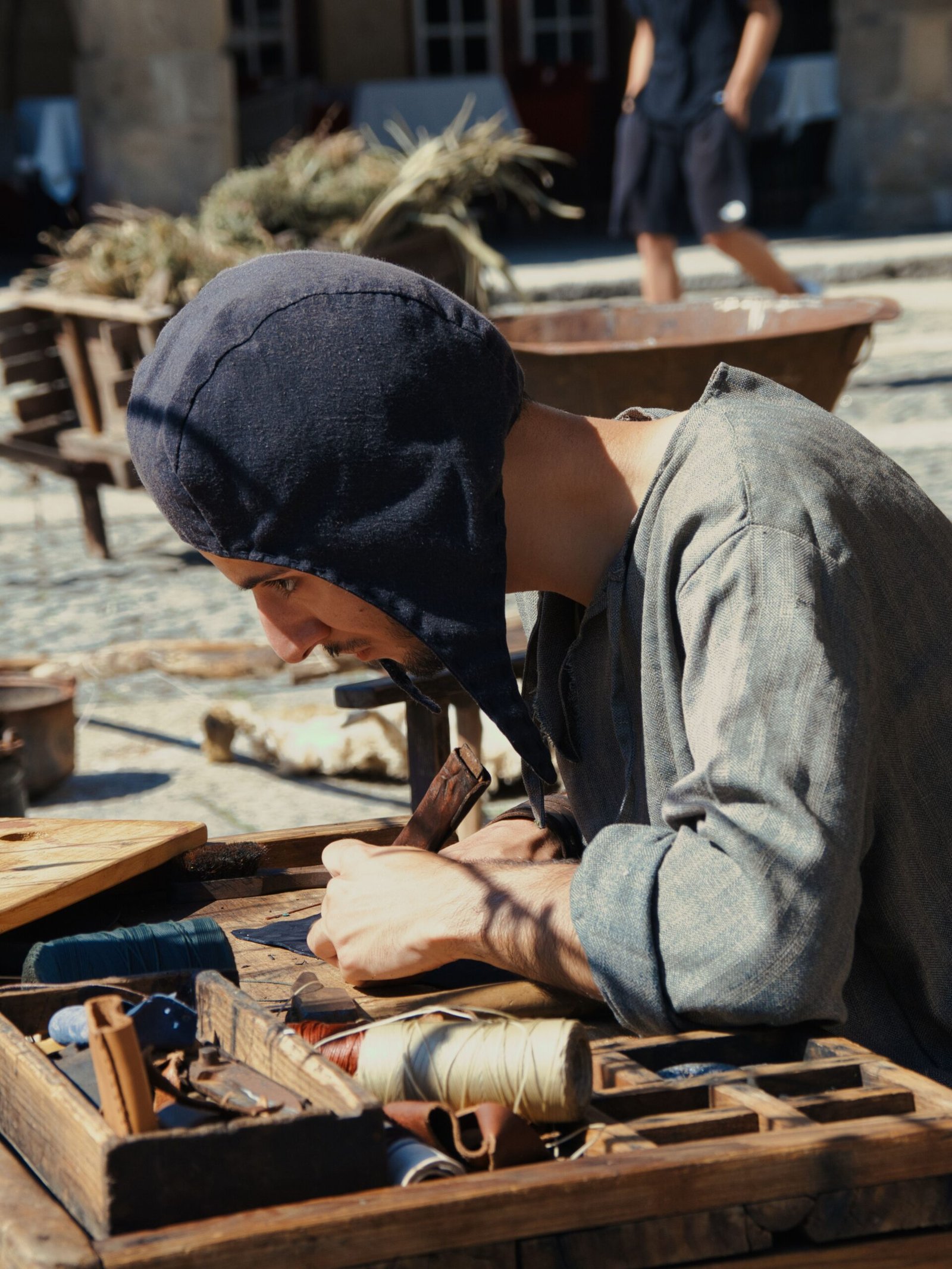 Woman in a headscarf working leather in a traditional workshop